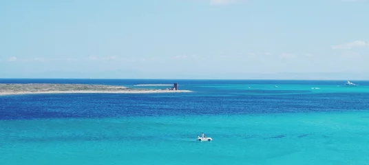Keuken foto achterwand La Pelosa Strand, Sardinië, Italië boot op zee. Sardinië eiland strand, Italië. Middellandse Zee. La Pelosa-strand, Stintino. turquoise wateren. Vakantie achtergrond. Ruimte voor tekst.