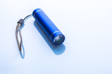 Blue pocket flashlight on white background - obrazy, fototapety, plakaty