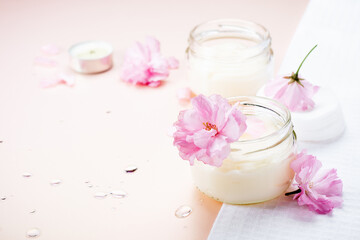 Obraz na płótnie Canvas Natural body care cream and pink flowers.