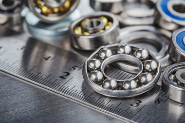 different bearings, vernier caliper and ruler on metal background. Part of mechanism.
