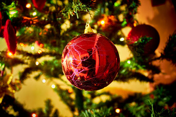 red christmas sphere with camera in reflection and christmas tree in the background and little bright lights horizontal picture