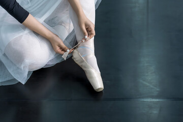 ballet dancer tie pointe shoe ribbon in ballet class