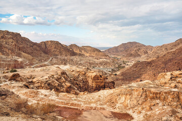 Rocky mountains landscape near Feifa, Jordan, overcast sky above, dead sea in distance