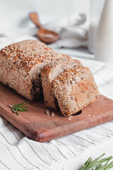 Healthy breakfast with sesame bread and milk. Sliced bread on a wooden board. Gluten free bread.
