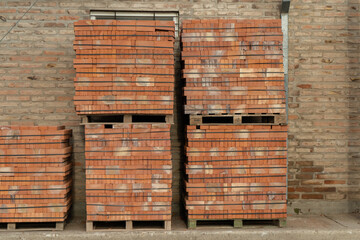 Pallets of orange bricks for construction. Front view.