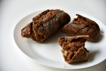 Pieces of black bread loaf on a white plate