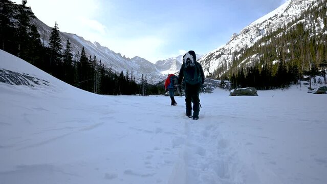 Hiking on a snow packed trail in the Glacier Gorge of Rocky Mountain National Park