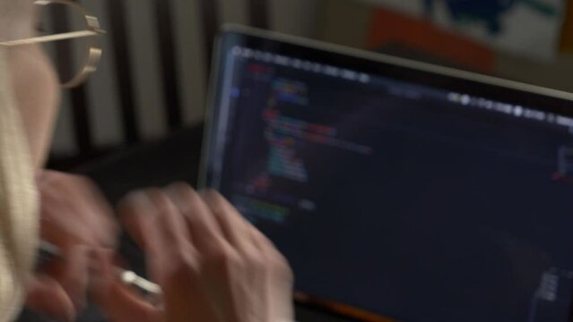 Woman developer coding on laptop computer. Close-up view face by side