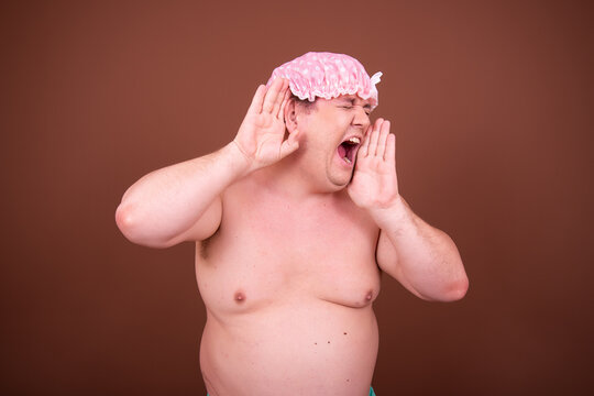 Funny fat man is washing himself in the shower.