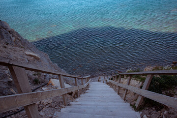 Wooden staircase leading from the mountains to the sea. Paradise place for tourism and recreation. Hiking.