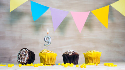 Birthday background with number 9. Beautiful birthday card with colorful garlands, a muffin with a...