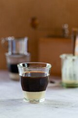 vietnamese coffee, dark roast coffee brewing with Vietnamese drip filter in glass on sweet condensed milk.