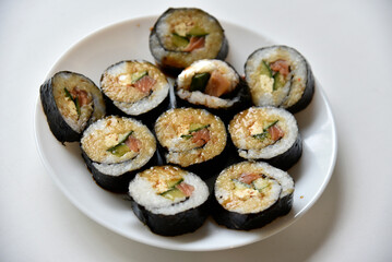 Rice rolls with salmon and cheese on a white plate. Japanese sushi.