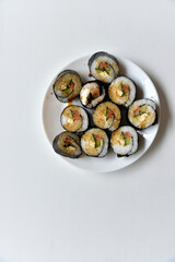 Rice rolls with salmon and cheese on a white plate. Japanese sushi.