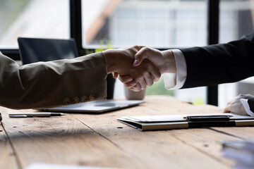 Managers and job applicants shake hands after the interview, resumes are important documents for job application. It should contain resume, training history, education, talent, work skills, etc.