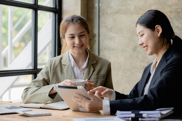 Two Asian business women are meeting to summarize the company's operating, financial, profit and loss results. Management of startup companies. Profitable management concept and growing management.