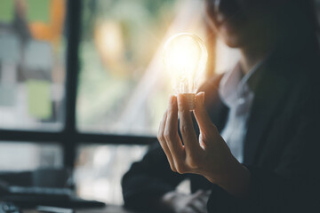 Standing woman holding glowing lamp, Creative new idea. Innovation, brainstorming, strategizing to...
