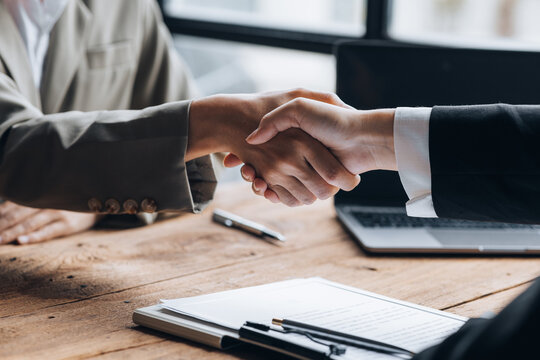 Managers and job applicants shake hands after the interview, resumes are important documents for job application. It should contain resume, training history, education, talent, work skills, etc.