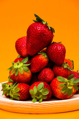 Fresh strawberries on orange background