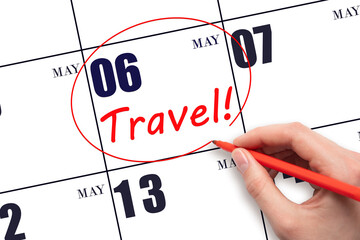 Hand drawing a red circle and writing the text TRAVEL on the calendar date 6 May. Travel planning.