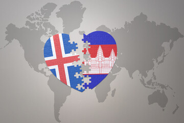 puzzle heart with the national flag of cambodia and iceland on a world map background. Concept.