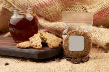 Homemade cookies, in the background honey in a glass, placed on a cutting board, in the background a jute bag made of natural fiber