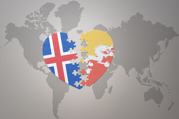 puzzle heart with the national flag of bhutan and iceland on a world map background. Concept.