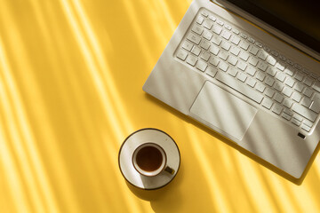 Computadora y café en fondo amarillo