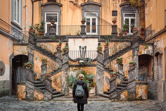 Woman looking at the famous staircases of Palazzo Marigliano, Naples, Italy. Palazzo Marigliano is a historical, renaissance-style  palace in Naples city center.