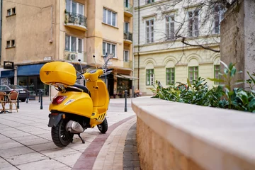 Zelfklevend Fotobehang Motor buiten. Gele retro-stijl scooter op de straat van de stad. © luengo_ua