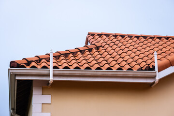 Naklejka premium Roof terracotta clay tiles house red tiled rooftop and guttering