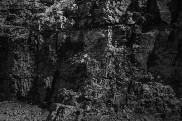 Grungy cragged bumpy pitted cavity stone facade, split layer gap.Ruined cracked shattered worn rough hiking canyon.Old ragged grunge steep marble cliff. Grand vintage crannied damaged impressive gorge