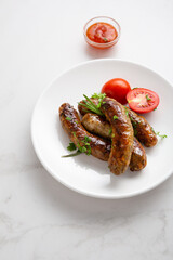 Sausages grilled with herbs, selective focus white plate