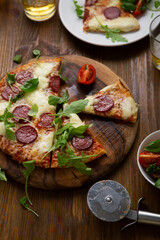 Overhead view of sliced pizza pepperoni on wooden table