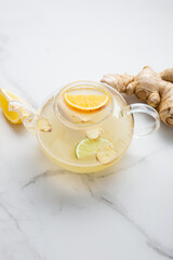 Glass teapot with ginger root and fruits tea