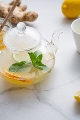 Glass teapot with ginger root and fruits tea for boost immunity