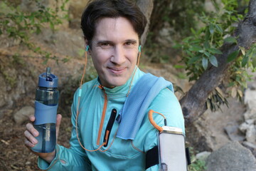 Healthy sportsman holding water bottle