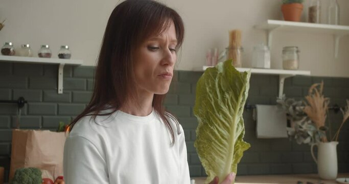 Dissatisfied woman eat green salad, healthy low-calorie diet for weight loss
