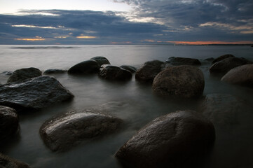 Baltic Sea shore with big stones in smooth water at long exposure