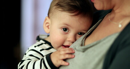 Happy smiling baby in mother arms. Parent holding adorable cute child smile