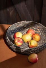 Apple and basket on a table with shadows