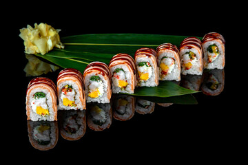 Sushi roll (Philadelphia) with salmon, mango, shrimp and philadelphia cheese on black background. Sushi menu. Japanese food.