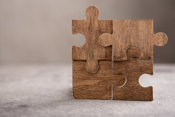 Creative idea and solve the problem concept. Teamwork success strategy - wooden puzzle on the grey...