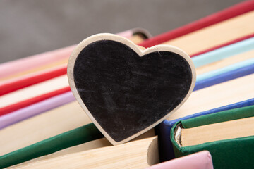 Love reading concept. Books and little wooden heart with space for text