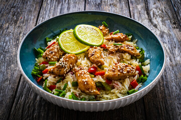 Teriyaki chicken nuggets with rice and vegetables on wooden table

