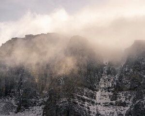 Sun illuminating fog over a mountain