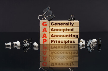 On a black reflective surface, wooden blocks with the inscription - Generally Accepted Accounting...