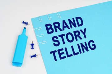 On a white surface, a marker, buttons and a blue sheet of paper with the inscription - Brand Story...