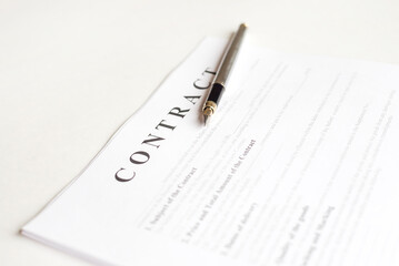 Pen for signing the contract. The pen and contract are on the laptop.