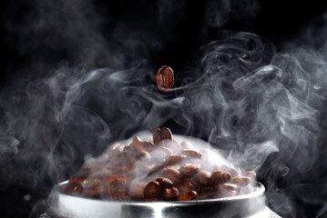 Heap of coffee beans in smoke. Close-up coffee.